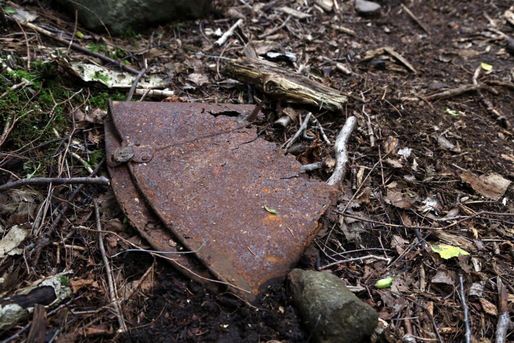 En rusten del av en bøtte dukket opp ved siden av stien, og utløste spørsmål om vrakdelene vi var på vei til.